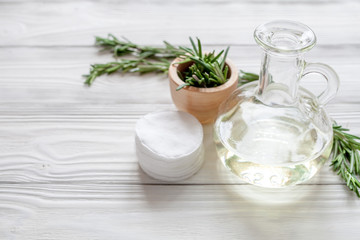 organic cosmetics with extracts of herbs rosemary on wooden background