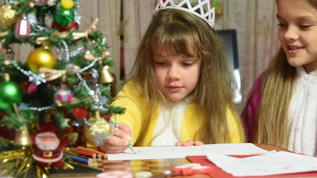 One girl draws a picture in the New Year's Eve, the other prevents it