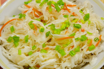 Квашеная порезанная капуста с морковью и зеленым луком.