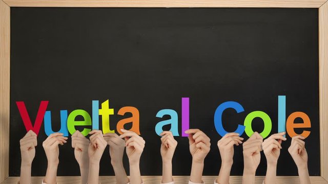 Hands holding up vuelta al cole