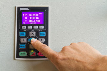 Forefinger touch on enter switch on control panel for machine controller.