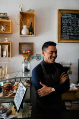 Happy hispanic barista working at a coffee shop