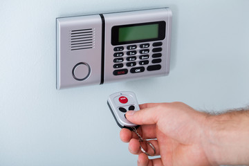 Person Hand Using Remote To Operate Security System