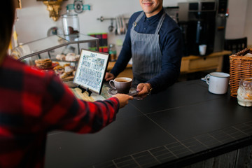 Latino barista serving a coffee