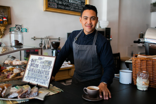 Hispanic barista serving a coffee