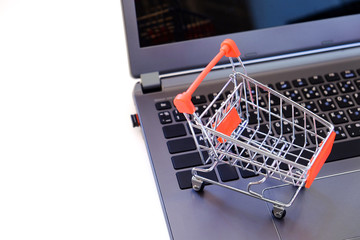 Red shopping cart and laptop on with background