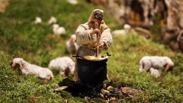 animated statuette of the crib of a woman who mixes the food in a cauldron