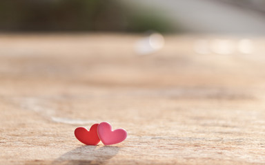 Pink and red hearts on old wooden floors with light and shadow.