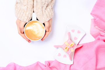 Female hands holding cup of cappuccino. Gift alike dessert with
