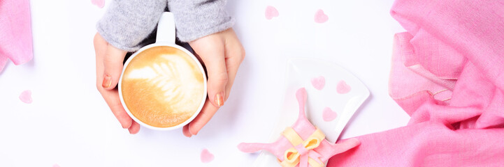 Female hands holding cup of cappuccino. Gift alike dessert with