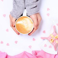 Fototapeta na wymiar Female hands holding cup of cappuccino. Gift alike dessert with