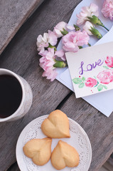 a cup of coffee with cookies on the wooden table 