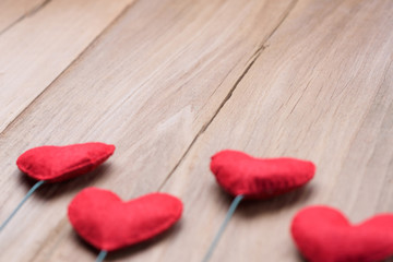 Valentines day concept of red heart shape decorations with old wood floor background.