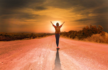 Fototapeta na wymiar Portrait of young backpacker woman on country road,sunset background