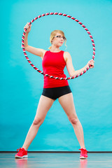 Fit woman with hula hoop doing exercise