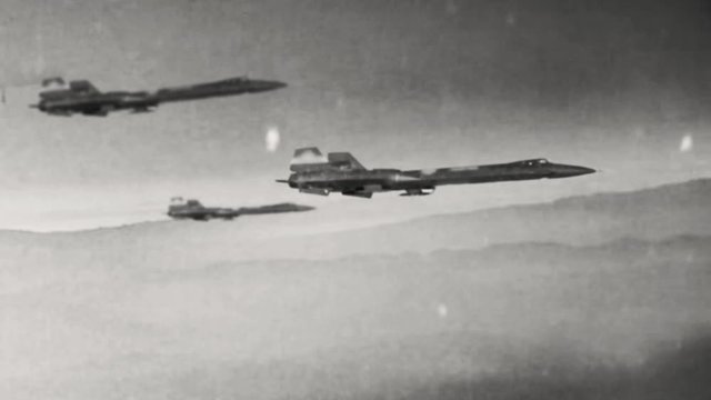 Animation of old style warplanes flying over a foreboding desolate wasteland into a battle