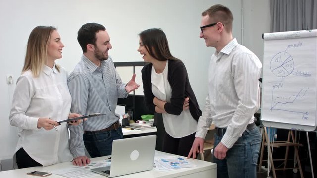 Positive office people laughing at a joke told by male coworker