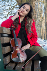 Girl posing with violin in winter ambient