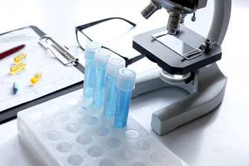 doctors desk with microscope and test tubes