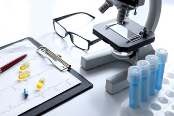 doctors desk with microscope and test tubes