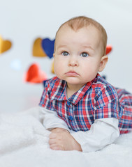 Little beautiful boy smiling among the heart.