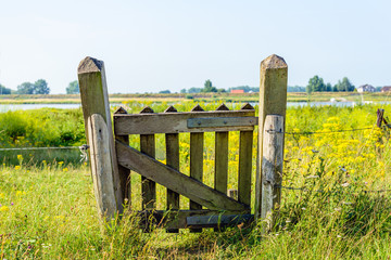 Small crooked wooden gate at the bank of a river