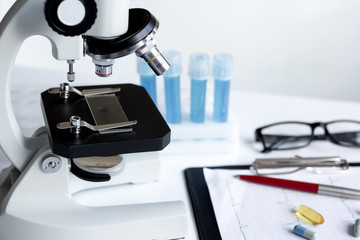 doctors desk with microscope and test tubes