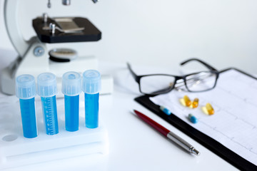 doctors desk with microscope and test tubes