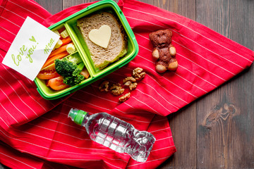 green lunch box for kid on wooden background top view