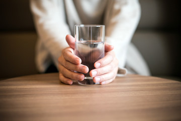 水の入ったコップを持つ女性