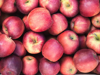 Background of red apples close up. Red, juicy, ripe apples top view. A lot of clean, neat apples on sale at the market