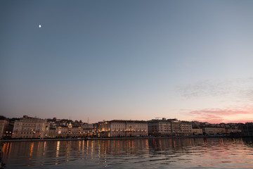 Fototapeta na wymiar Reflections on the sea of Trieste at dusk - Historical buildings and lights