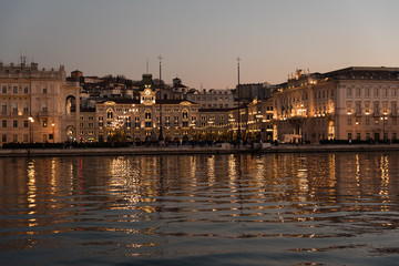 Obraz premium Reflections on the sea of Trieste at dusk - Historical buildings and lights