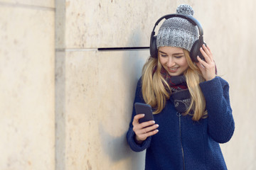 Junge glückliche Frau hört Musik mit Kopfhörern