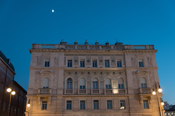 Fototapeta na wymiar Reflections on the sea of Trieste at dusk - Historical buildings and lights