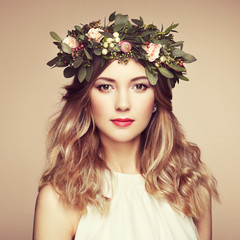 Naklejka premium Beautiful blonde woman with flower wreath on her head. Beauty girl with flowers hairstyle. Perfect makeup. Beauty fashion. Spring woman