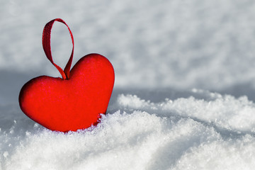 Red heart on the snow. Christmas decorations