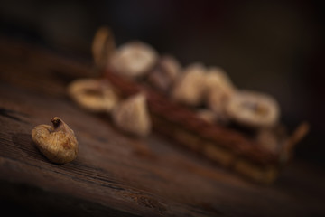 Dried figs in a small basket on wooden background