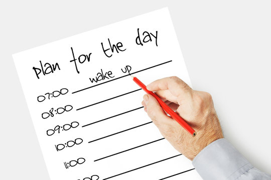 Man writes a plan for the day on the paper sheet