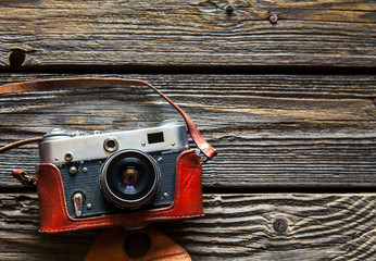 Retro camera on wood table background, vintage color tone