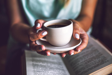 Girl with a cup of coffee and a book. Wakes up, morning, break,