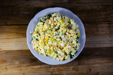 Salad with crab sticks, corn, cucumber, and eggs