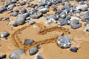 Heart symbol on the sand beach on a sunny day