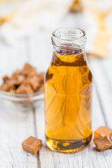 Caramel Sirup (selective focus) on vintage wooden background