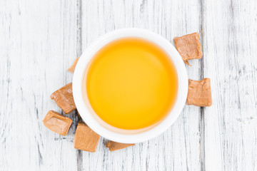 Caramel Syrup on wooden background (selective focus)