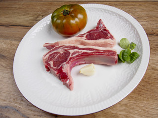 Two lamb chops wiht tomato and garlic in a plate