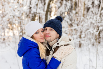 The guy and the girl have a rest in the winter woods.