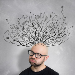 VIew of a Young attractive bored geek man with brainstormaing arrow over the head