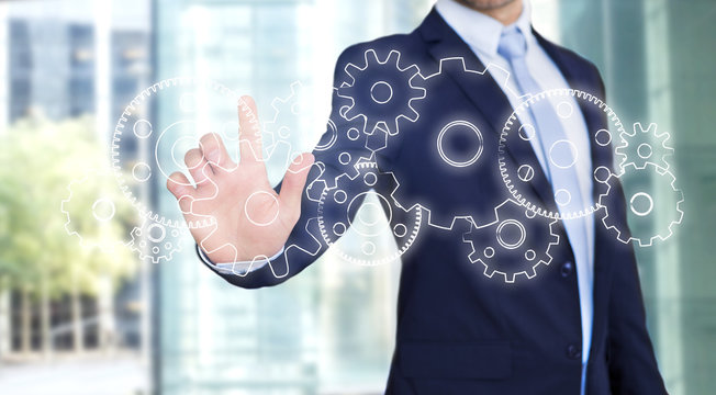 Businessman touching technology interface with gear wheel settin