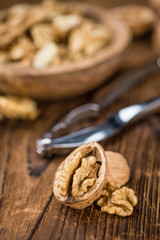 Portion of Cracked Walnuts on wooden background (selective focus